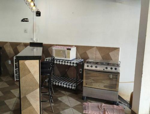 a kitchen with a stove and a microwave at Cachoeira Paulista Espaço Cassicay in Cachoeira Paulista