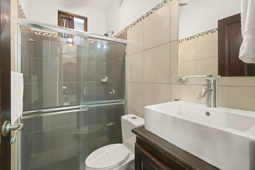 a bathroom with a toilet and a sink and a shower at Casa Arrecifes in Coco
