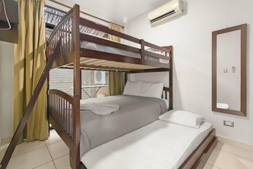 a bedroom with two bunk beds and a mirror at Casa Arrecifes in Coco