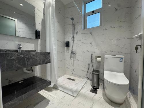 a white bathroom with a toilet and a sink at Najd Cozy Apartment in Dammam
