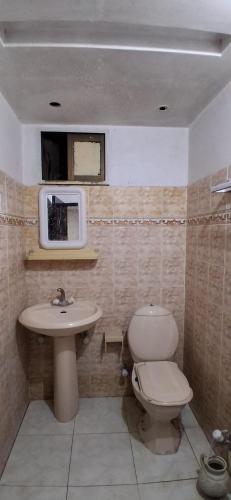 a bathroom with a toilet and a sink and a microwave at Mughal E Azam Hotel in Murree