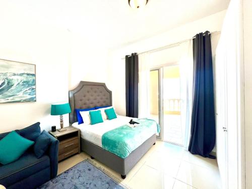 a bedroom with a bed and a couch at Royal Breeze Executive Studio in Ras al Khaimah