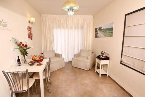 a living room with a table and a chair and a room at Achuza Bamarom in Safed