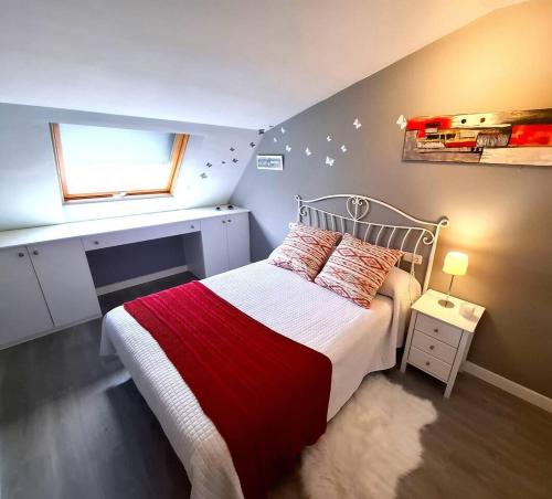 a small bedroom with a bed and a window at Dúplex 4 dormitorios Playa Foz in Foz