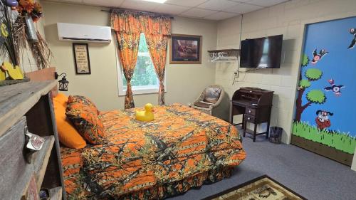 a room with a bed and a desk and a tv at Medley Manor in East Peoria