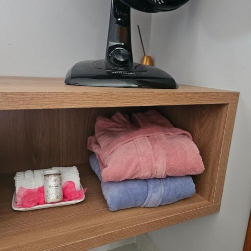 a wooden shelf with some towels at Casinha de Aldeia in Aldeia Velha