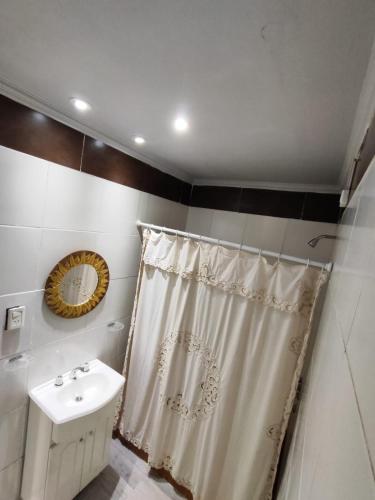 a bathroom with a shower curtain and a sink at Depto Pringles 1740 PB Parking Privado Gratis in Yerba Buena