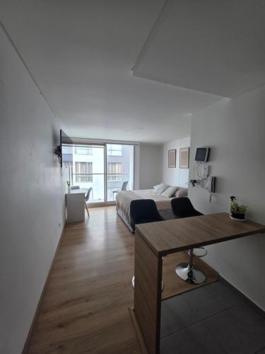 a bedroom with a bed and a desk in a room at Cozy studio apartment with a privileged view in Manizales