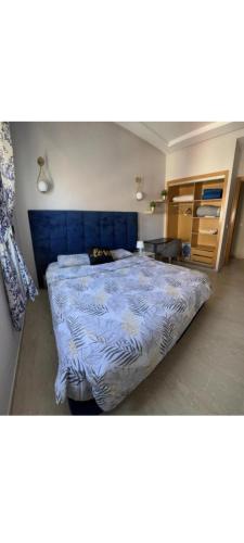 ein Schlafzimmer mit einem großen Bett mit blauem Kopfteil in der Unterkunft infinity by Hadil-Rabat centre ville in Rabat