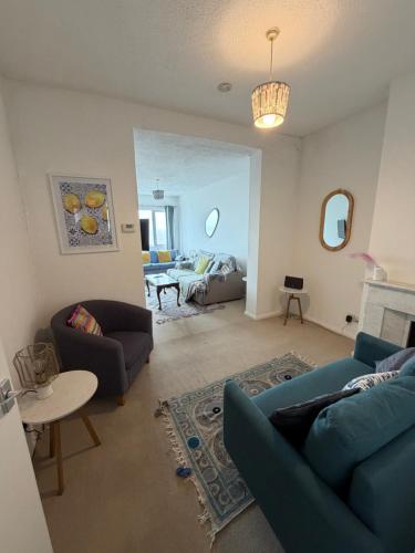 a living room with a blue couch and a bed at Captain Normans Sea view in Hollington