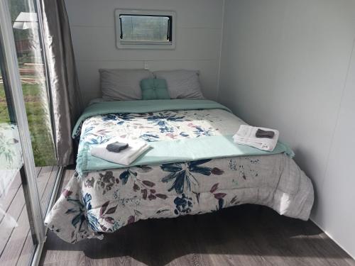 a small bedroom with a bed with a comforter at Blackcomb Apple Pod in Klamath