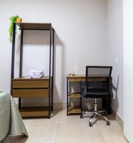 a bedroom with a desk and a chair next to a mirror at MOOVE Stay - Suite Cacau no centro in Uberlândia