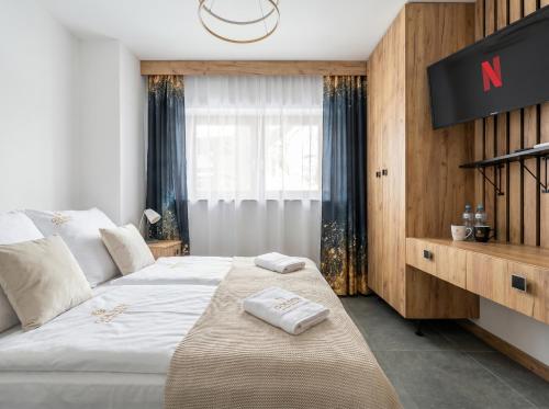 a bedroom with a bed with two towels on it at Golden Apartments - Tatra View - Księżycowe Apartamenty SPA - 24d-1 in Zakopane