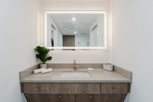 a bathroom with a sink and a mirror at The Courtyard - Poolside Suite in Boca in Boca Raton
