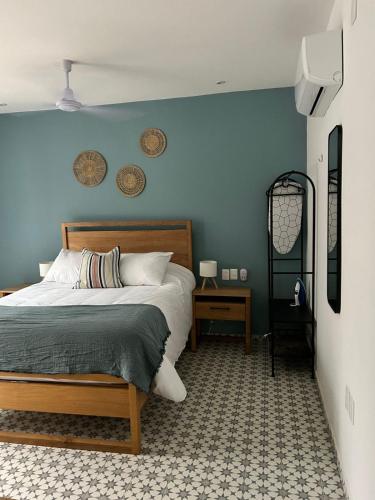 a bedroom with a bed and a blue wall at Casa Andres in Guadalajara