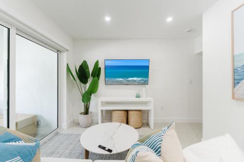 a white living room with a white couch and a table at The Courtyard - Poolside Suite in Boca in Boca Raton
