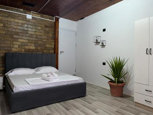 a bedroom with a bed and a brick wall at Hub 1001 Berat Hostel in Berat