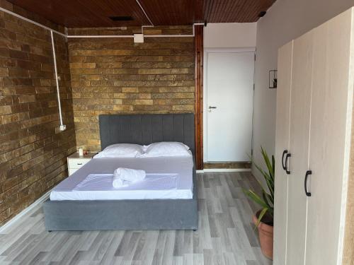 a bedroom with a bed and a brick wall at Hub 1001 Berat Hostel in Berat