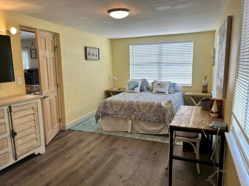 a bedroom with a bed and a television and a table at Conch Shell Cabana in Vero Beach