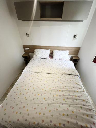 a bed with polka dots on it in a bedroom at Mobile home in Litteau