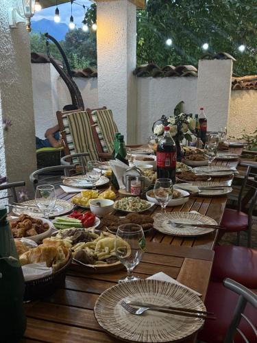 a long wooden table with plates of food on it at Leila's Guest House in Joqolo