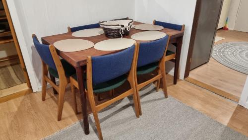 a wooden table with blue chairs around it at Casa del Amor in Hyldtofte