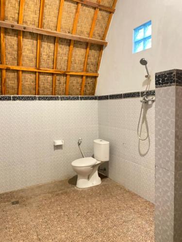 a bathroom with a toilet and a shower at Griya Garden Penida in Nusa Penida