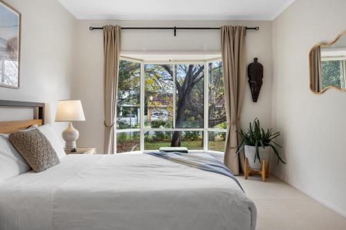 a bedroom with a bed and a large window at Salt & Stay - Laid-Back Comfort by the Beach in Encounter Bay