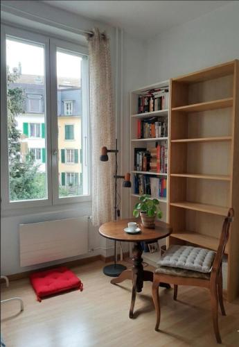 a living room with a table and a window at Bern room near Main Station in Bern