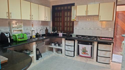 a kitchen with white cabinets and black counter tops at Casa com 2 quartos em excelente localização in Juazeiro do Norte