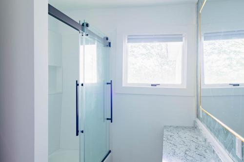 a glass shower in a bathroom with a window at Sweet Stowe Apartment in Stowe