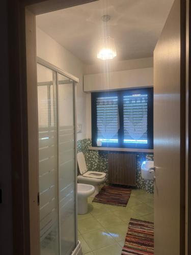 a bathroom with a toilet and a glass shower at Trevisan in Cerea