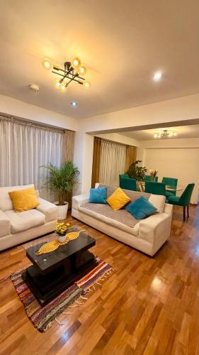 a living room with two couches and a table at Amatista Apartment in Cusco
