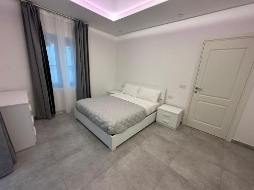a white bedroom with a bed and a window at Residenza del Lago in Viverone