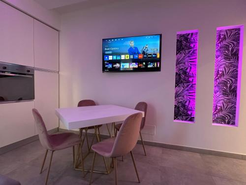a dining room with a table and a tv on a wall at Residenza del Lago in Viverone