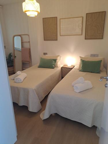 two beds sitting next to each other in a room at Costa Canido I in Malpica