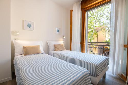 two beds sitting in a room with a window at Nida 18 in Cattolica
