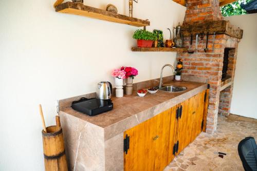 a kitchen with a counter with a sink and a brick wall at PIK Residence in Mostar