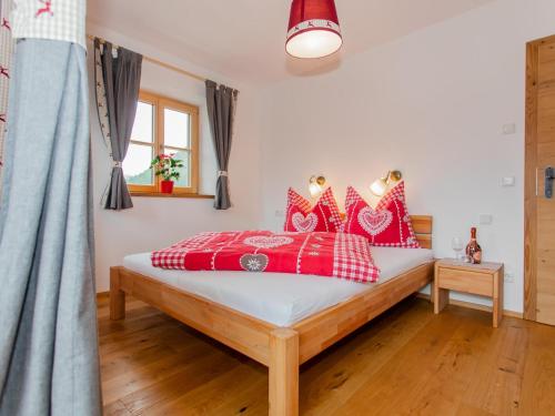 a bedroom with a bed with red pillows at Das Rendlgut Top 3 in Lofer