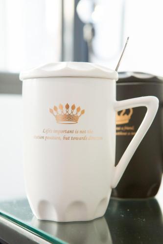 Eine weiße Kaffeetasse mit einer Krone drauf. in der Unterkunft Live in the Happiness in Zhushan