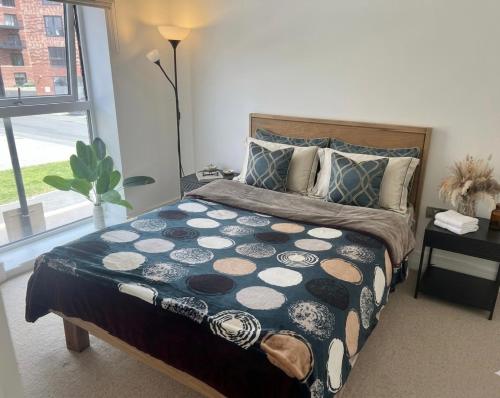 a bedroom with a large bed with a large window at Modern Townhouse Birmingham in Birmingham