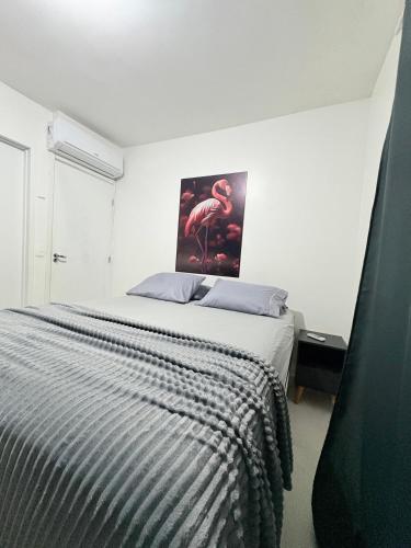 a bedroom with a bed with a picture of a flamingo at Apê moderno perto do shopping - WI-FI rápido e garagem in Caruaru