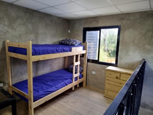 two bunk beds in a room with a window at Sierras Cosquin in Cosquín