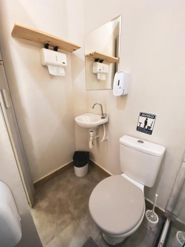a small bathroom with a toilet and a sink at Garibaldi Hostel & Pub in Curitiba