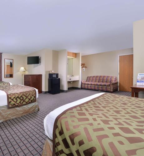 a hotel room with two beds and a couch at Regency Inn Geneseo IL in Geneseo