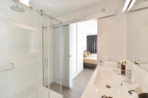 a white bathroom with a tub and a sink at Gran Rapido - Modern 1 bedroom apartment very close to Yumbo in Playa del Ingles