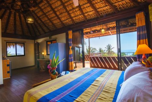 a bedroom with a bed with a view of the ocean at Hotel Casamar Suites in Puerto Escondido