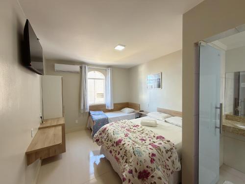 a bedroom with a bed and a television in it at Hotel C Diamantina in Vitória da Conquista