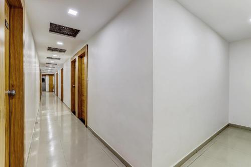 an empty hallway with white walls and a white floor at Hotel O Maple view in Naroda