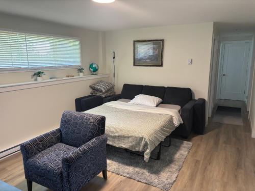 a living room with a bed and a couch and a chair at Private Guest Suite In Colwood in Colwood